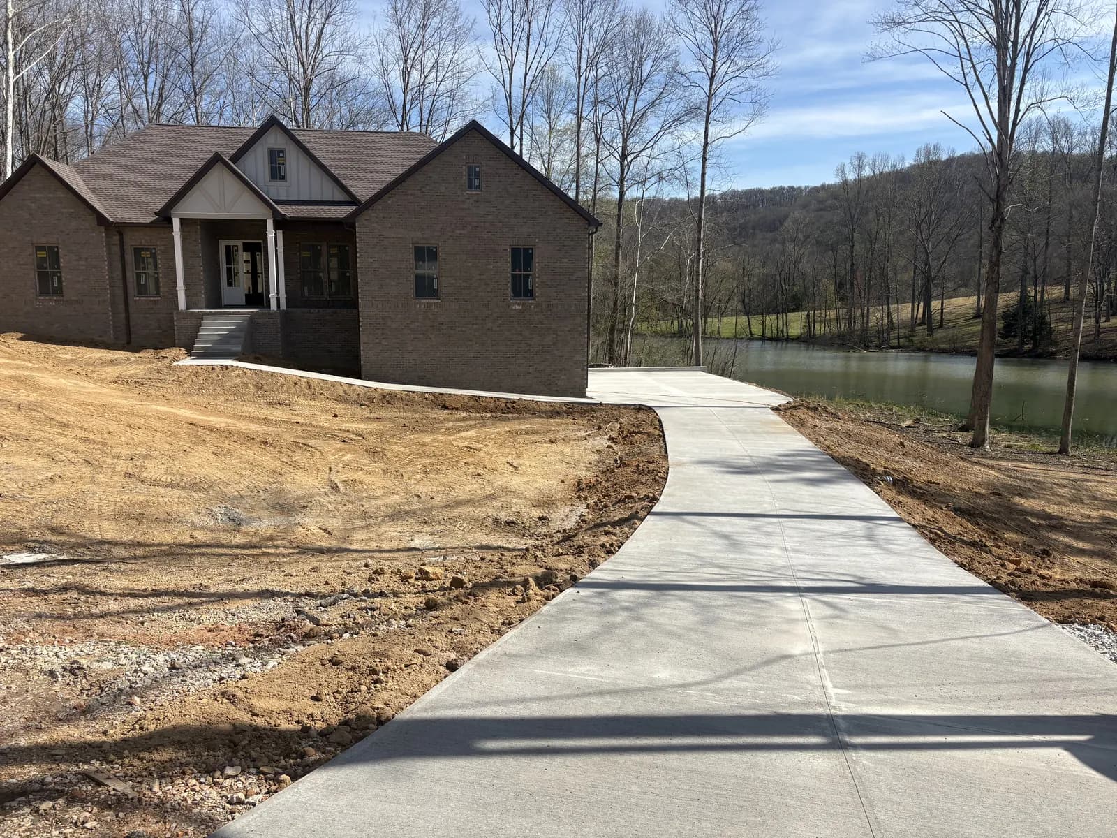 New concrete driveway curving up to a brick home in Cookeville