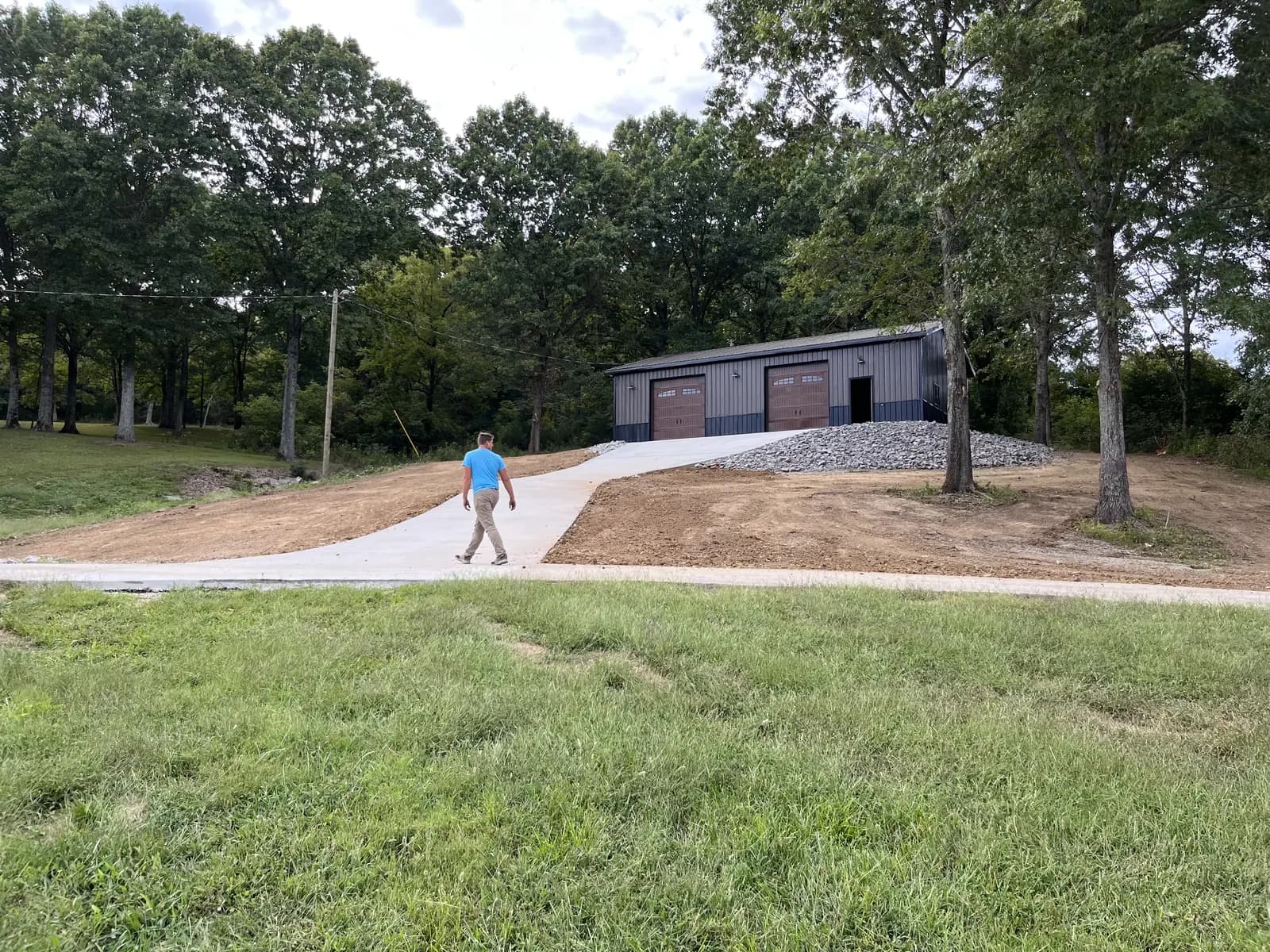 Concrete driveway running to a detached two bay shop building