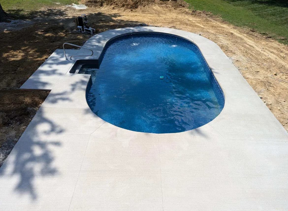 Broom finished concrete pool deck surrounding an inground pool