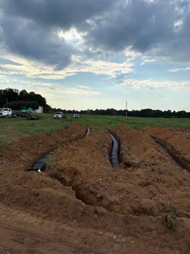Excavator trenching field lines on a residential job site