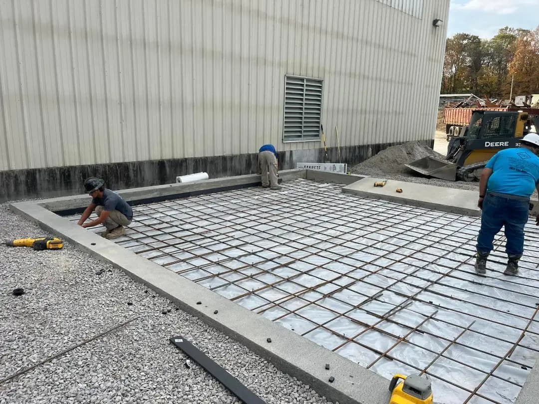 Crew setting rebar on a prepared slab before a pour